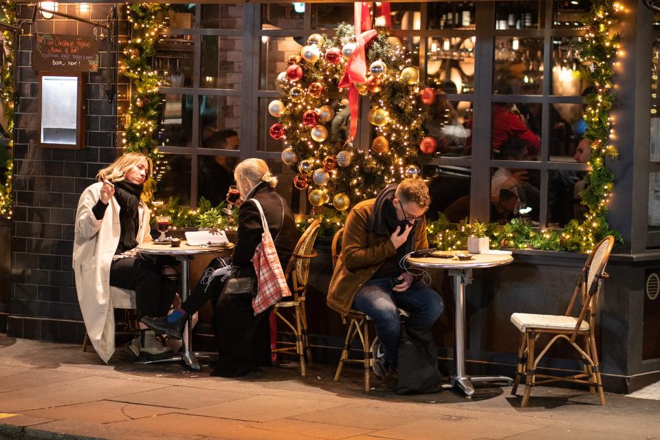 People eat outside a pub in central London (PA Wire)