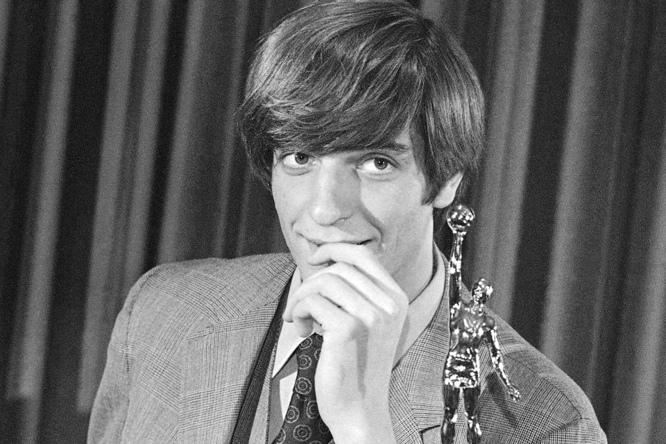 FILE - Pete Maravich leans on his trophy and jokes with newsmen in Atlanta, March 26, 1970, after being named college basketball's player of the year. Those who played with, followed or knew the late Maravich are conflicted about the seemingly inevitable moment — likely this Sunday — when he could be supplanted by Iowa women's basketball sensation Caitlin Clark atop the NCAA's all-time scoring list.(AP Photo/File)