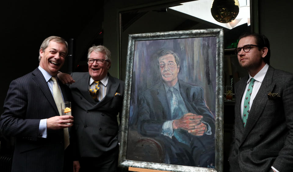 (left to right) Nigel Farage, comedian Jim Davidson and artist Dan Llywelyn Hall, stand beside a portrait titled Mr Brexit, at L'Escargot Restaurant in London.