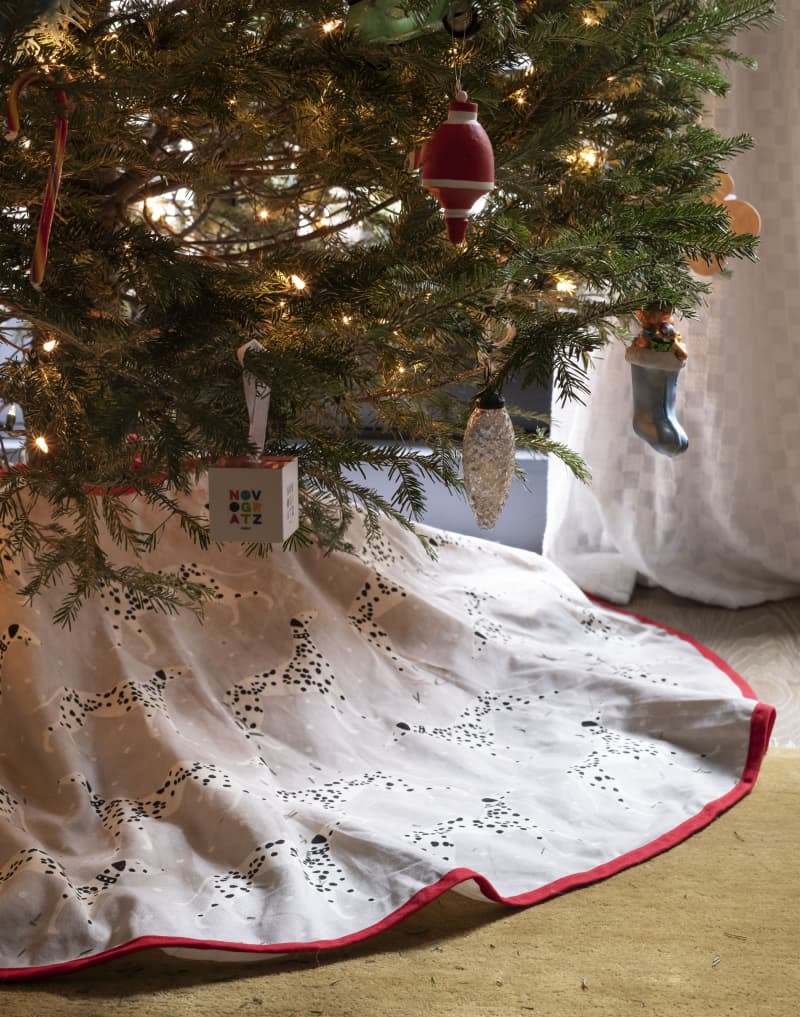 Christmas tree sits decorated in the corner of a room