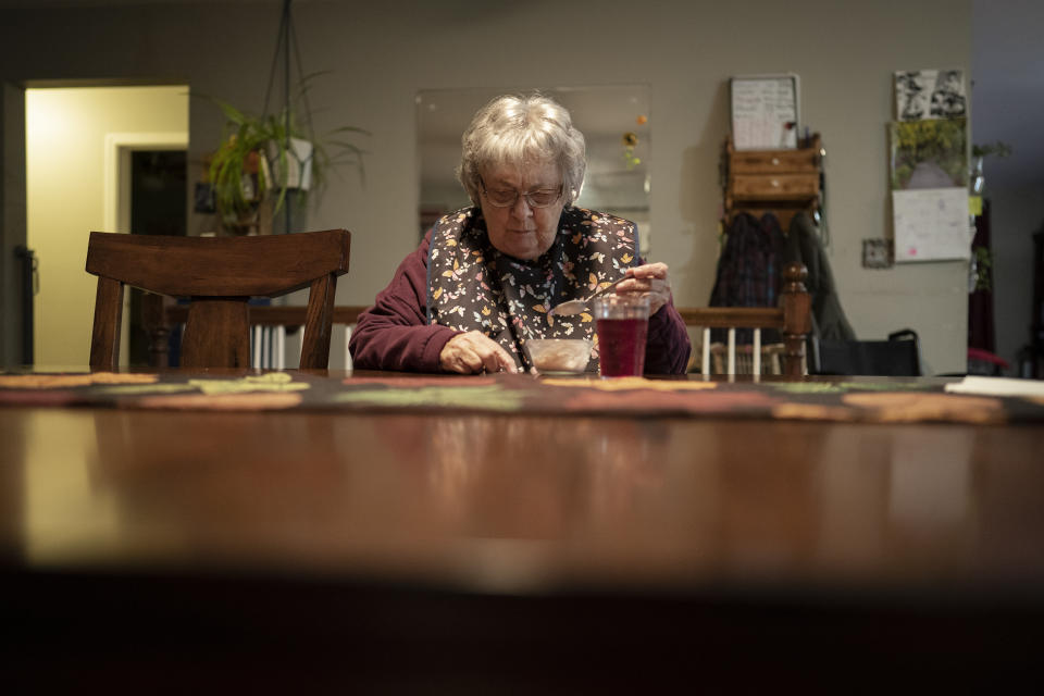 Betty Bednarowski traces the patterns on her placemat while having dinner, Monday, Nov. 29, 2021, in Rotterdam Junction, N.Y. (AP Photo/Wong Maye-E)