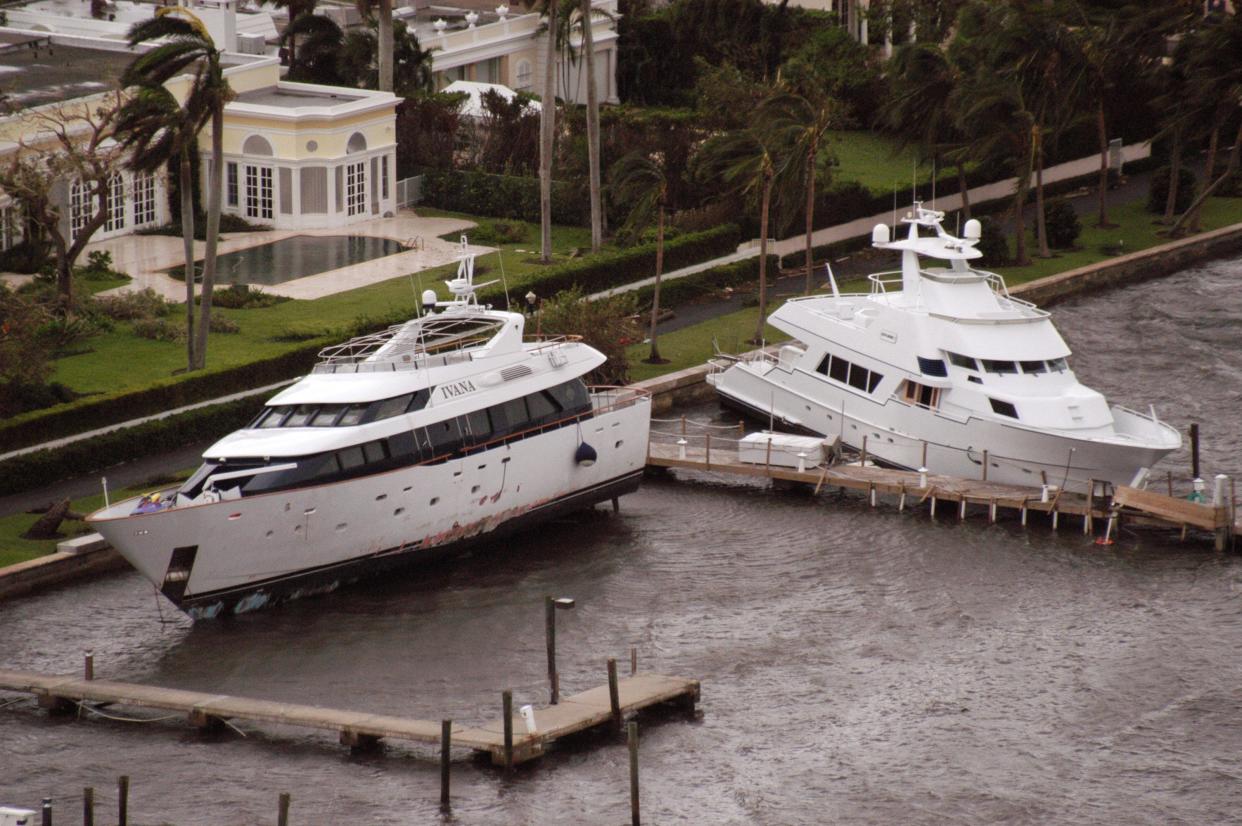 Former President Donald Trump's ex-wife Ivana Trump's yacht, IVANA, lies against the seawall next to mansions in Palm Beach in 2004 after Hurricane Frances passed through the area.