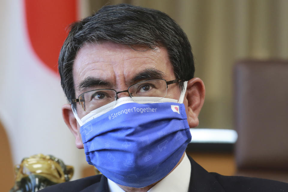 FILE - In this March 29, 2021, file photo, Japanese Vaccine Minister Taro Kono wearing a face mask with Japanese and EU flags on it speaks during an interview in Tokyo. Kono said on Thursday, April 15, 2021, even if the Olympics go on, there may be no fans of any kind in the venues. He said it's probably Olympics will have to held in empty venues, particularly as cases surge across the country. (AP Photo/Koji Sasahara, File)