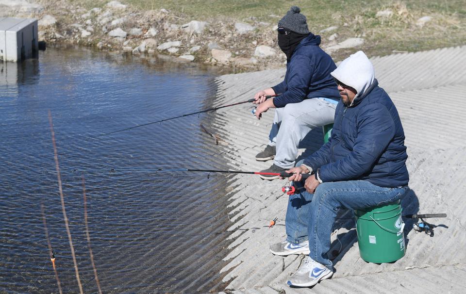 People enjoy fishing in the cold and windy weather at the Spring Fishing Day hosted by Ames Parks and Recreation and JAX Outdoor Gear at Ada Hayden Park Saturday, April 16, 2022, in Ames, Iowa.