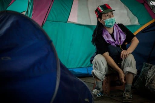 A woman sits at a protesters' camp outside HSBC bank headquarters in Hong Kong on August 13, 2012. he High Court gave the Hong Kong protesters 14 days to leave the courtyard of the bank's downtown office tower, after which HSBC would be entitled to reclaim the site