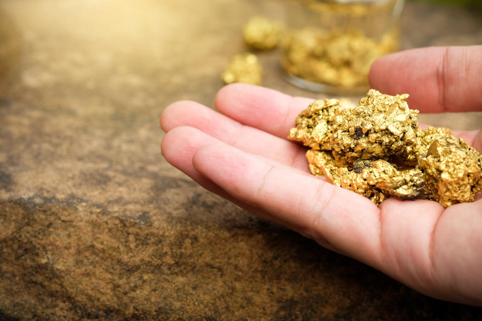 A hand holding gold pieces