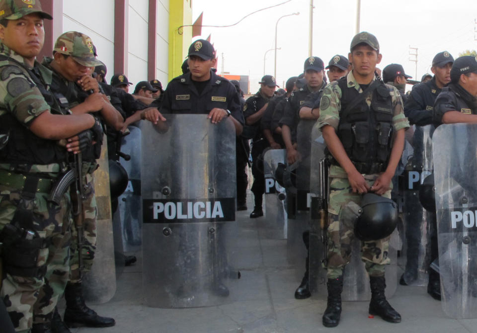 In this April 7, 2014 photo, police stand guard outside the auditorium in Chimbote, Peru. Inside, Congress’ investigations committee had just heard from an angry public that has long been living in fear accuse Gov. Cesar Alvarez of running mining-rich Ancash state as his personal fiefdom. At the hearing, Peru’s chief prosecutor, comptroller and the committee chair all apologized for failing to prevent a political murder whose victim’s longstanding campaign to expose wrongdoing in Ancash had been all but ignored in the capital. (AP Photo/Frank Bajak)