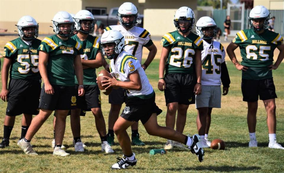 Le Grand High School sophomore quarterback Diego Martinez (5) rolls out to deliver a pass during practice on Thursday, Aug. 10, 2023.