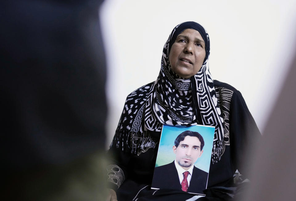 Nidal Ali holds a photo of her missing son in Mahmoudiya, south of Baghdad, Iraq, Tuesday, March. 28, 2023. Their sons were both kidnapped by extremist groups in 2014. Though active conflict in Iraq has largely subsided, many are still waiting to learn the fate of missing loved ones who disappeared during the US invasion, the subsequent civil war, or during the war against the Islamic State. (AP Photo/Hadi Mizban)