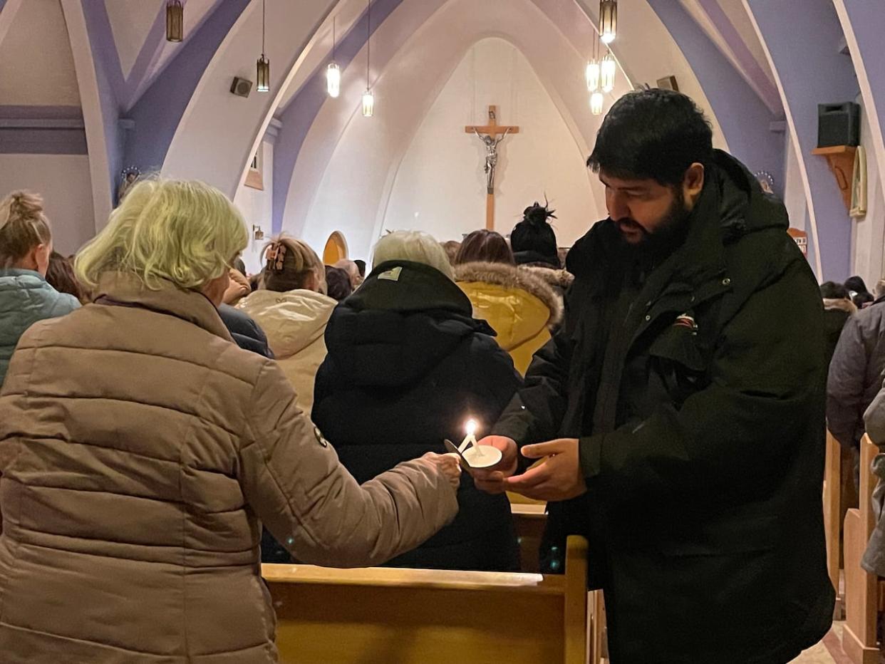 Community members in Fort Smith, N.W.T., are shown here attending a vigil on Jan. 24 for those who died in a Northwestern Air plane crash. The municipal government recently launched fundraising campaigns to help the victims' families and the lone crash survivor. (Natalie Pressman/CBC - image credit)