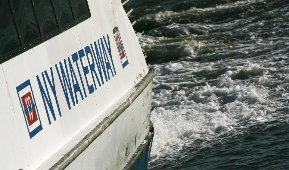 A NY Waterway ferry is shown pulling away from a terminal.