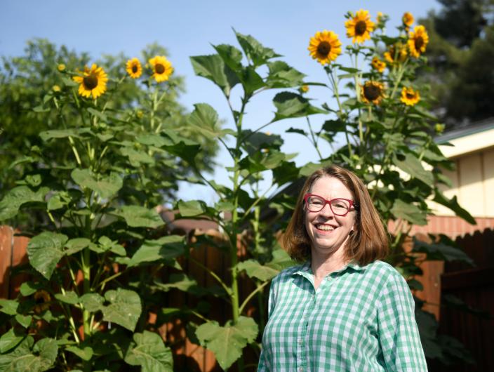 Becky Miller stands in front of her sunflowers, Friday, June 17, 2022. &quot;To garden in Lubbock is to suffer,&quot; Miller says about West Texas' severe gardening conditions and the trial and error it takes to plant.