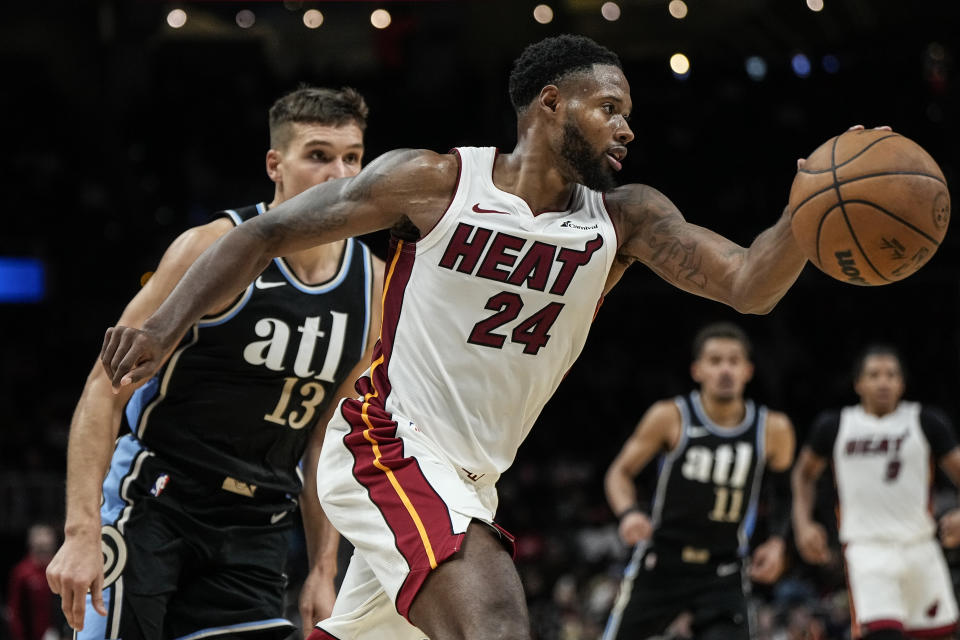 Miami Heat forward Haywood Highsmith (24) moves past Atlanta Hawks guard Bogdan Bogdanovic (13) during the second half of an NBA basketball game, Saturday, Nov. 11, 2023, in Atlanta. The Miami Heat won 117-109. (AP Photo/Mike Stewart)