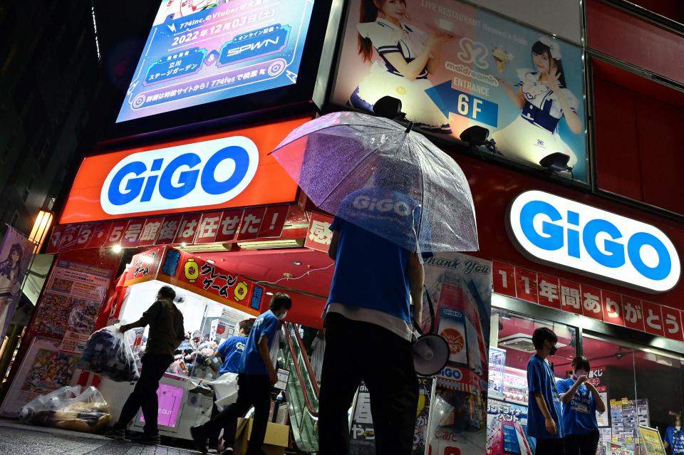 This photo taken on September 23, 2022 shows a member of staff (C) watching for visitors outside the GiGO Akihabara Building number 4, previously known as the Sega Akihabara Building number 4, which was filled with floors of arcade and video games, in the popular electronics shopping area of Akihabara in Tokyo. - With the arcade industry struggling with fewer visitors due to Covid-19 and a trend to online gaming, the arcade - located directly opposite the train station - closed its doors on September 25 after the lease expired. (Photo by Richard A. Brooks / AFP) (Photo by RICHARD A. BROOKS/AFP via Getty Images)