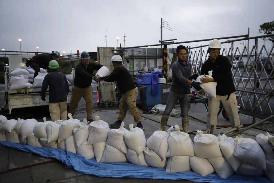 Workers stack sandbags at a construction site in preparation for Typhoon Hagibis on Enoshima Island, Kamakura, west of Tokyo, Friday, Oct. 11, 2019. A typhoon was forecast to bring 2 feet of rain and damaging winds to the Tokyo area and central Japan's Pacific coast this weekend, and the government warned people Friday to stockpile and leave high-risk places before it's too dangerous. (AP Photo/Jae C. Hong)