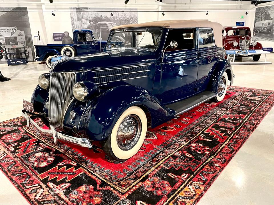 A 1936 Ford Deluxe Convertible Sedan gleams in the Ford museum as it would have in the showroom.