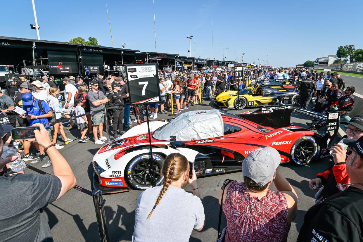Fans take photos of the No. 7 Porsche GTP car during the popular grid walk before the IMSA main event last summer.