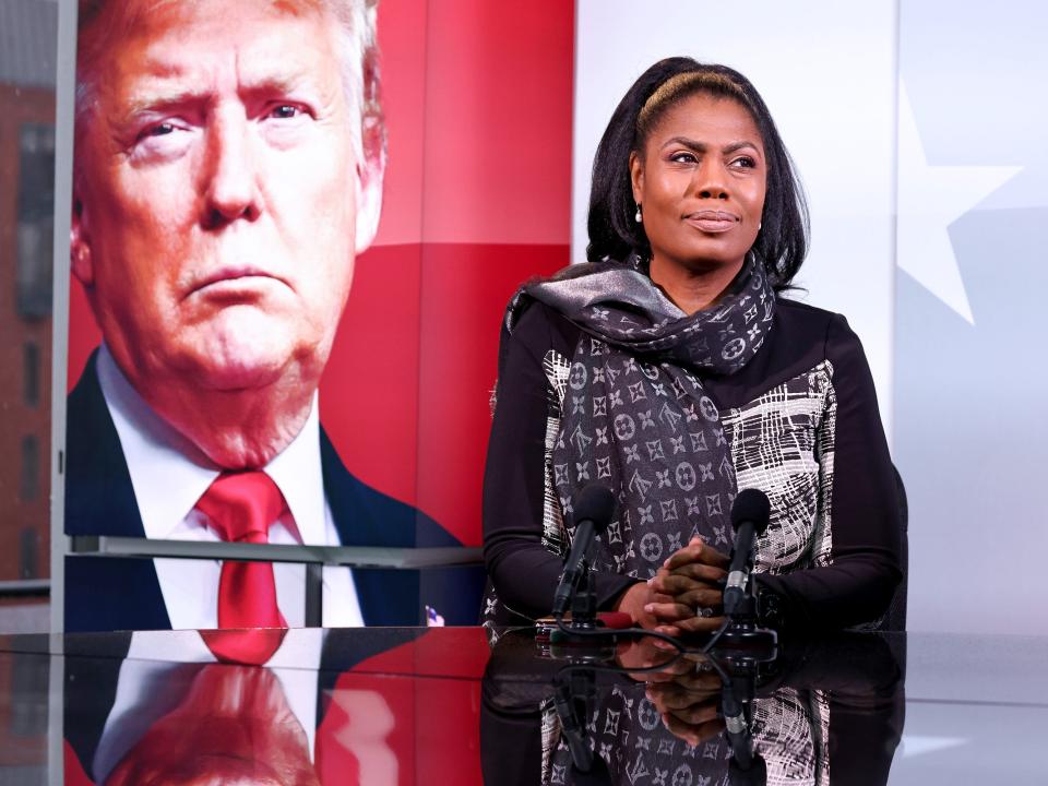 Omarosa Manigault Newman in front of an image of Trump