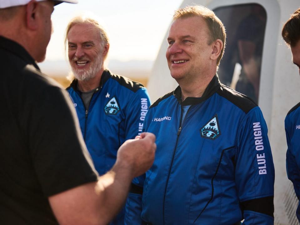 Hamish Harding smiles as he is handed a pin in front of the Blue Origin lander.