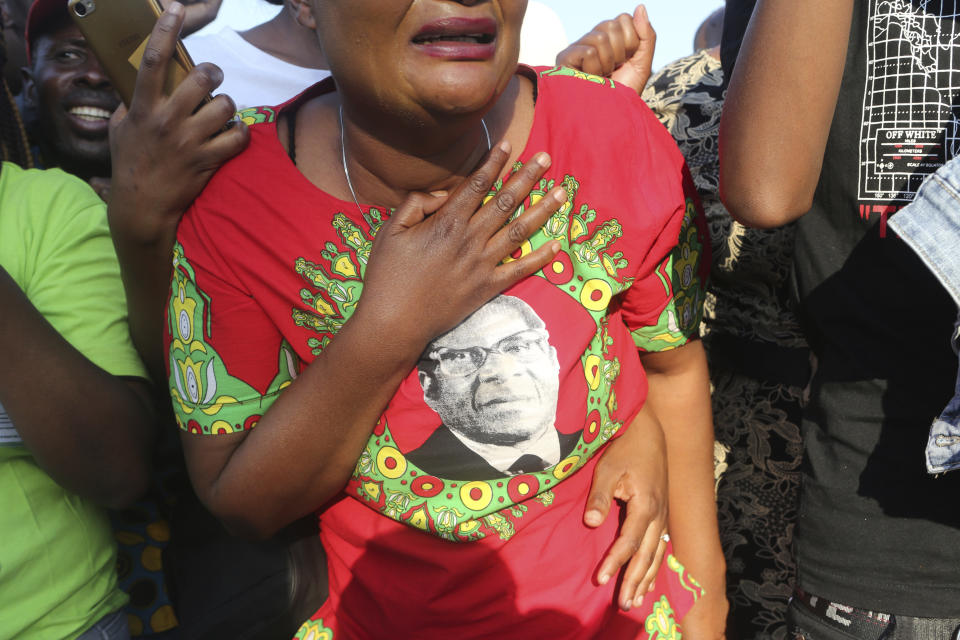 Supporters of Zimbabwe's former ruler, Robert Mugabe react upon the arrival of his remains at at RG Mugabe airport in Harare,Wednesday, Sept, 11, 2019.(AP Photo/Tsvangirayi Mukwazhi)