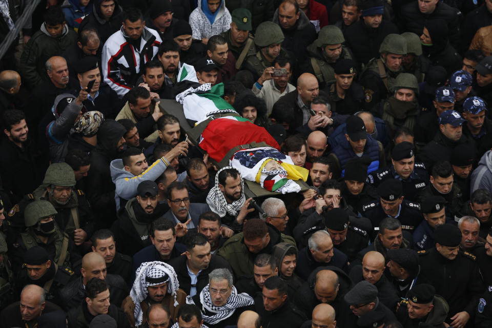 Palestinians carry the body of policeman Tariq Badwan during his funeral in the West Bank village of Azoun near Qalqilya, Friday, Feb. 7, 2020. Badwan was shot while standing at the entrance of a police station in Jenin, where Israeli forces clashed with Palestinians while demolishing the home of an alleged militant. He did not appear to have been involved in the clashes. (AP Photo/Majdi Mohammed)