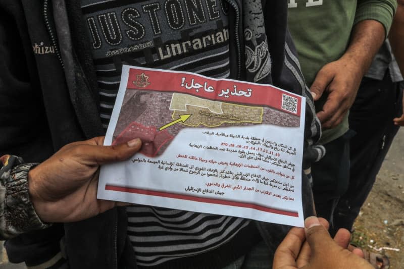 Palestinians holds a leaflet dropped by the military aircraft of the Israeli army on the east of the city of Rafah, ordering them to evacuate and move towards the west of the city and the city of Khan Yunis. The leaflet says that all residents of eastern Rafah must evacuate immediately. The aforementioned area is area of conflict and fighting. Abed Rahim Khatib/dpa