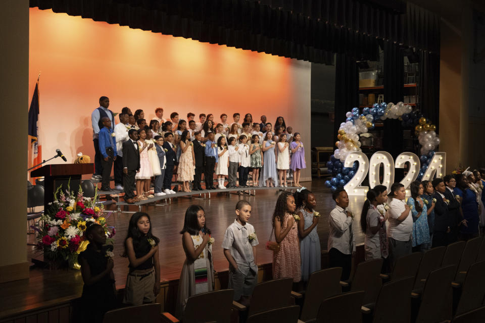 Alumnos cantan el himno nacional durante una ceremonia de graduación de P.S. 145 The Bloomingdale School, el viernes 21 de junio de 2024 en Nueva York. (AP Foto/Jeenah Moon)