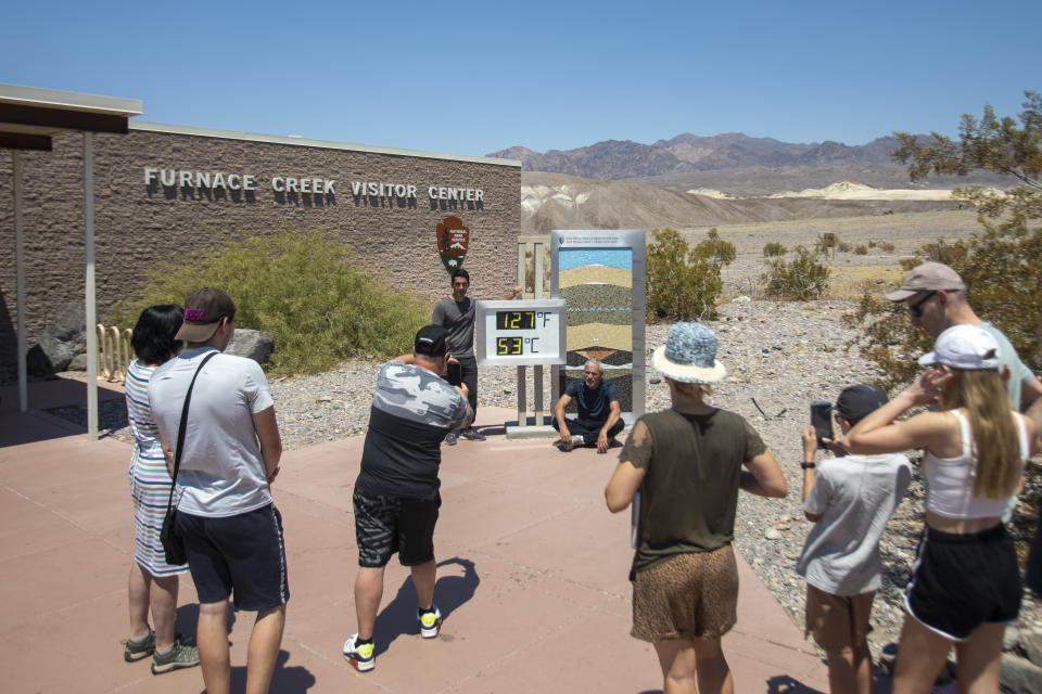 Tourists take photos in front of the Furnace Creek visitor center thermometer Monday, July 8, 2024, in Death Valley National Park, Calif. (Daniel Jacobi II/Las Vegas Review-Journal via AP)