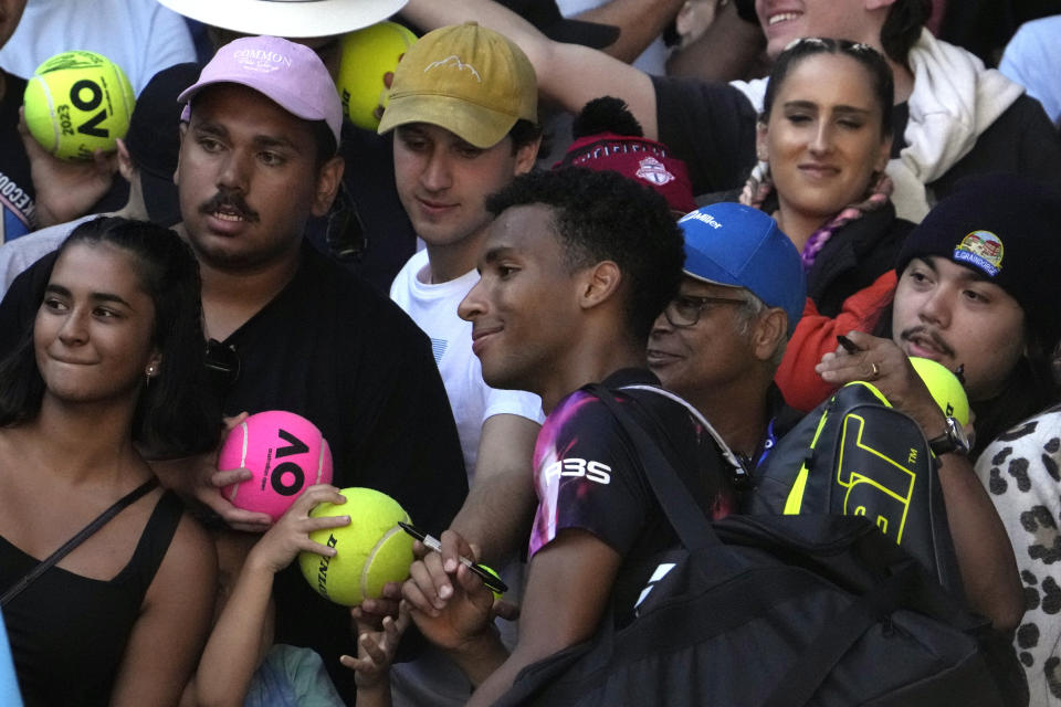 Felix Auger-Aliassime of Canada poses for a photo with fans after defeating Francisco Cerundolo of Argentina in their third round match at the Australian Open tennis championship in Melbourne, Australia, Friday, Jan. 20, 2023. (AP Photo/Ng Han Guan)