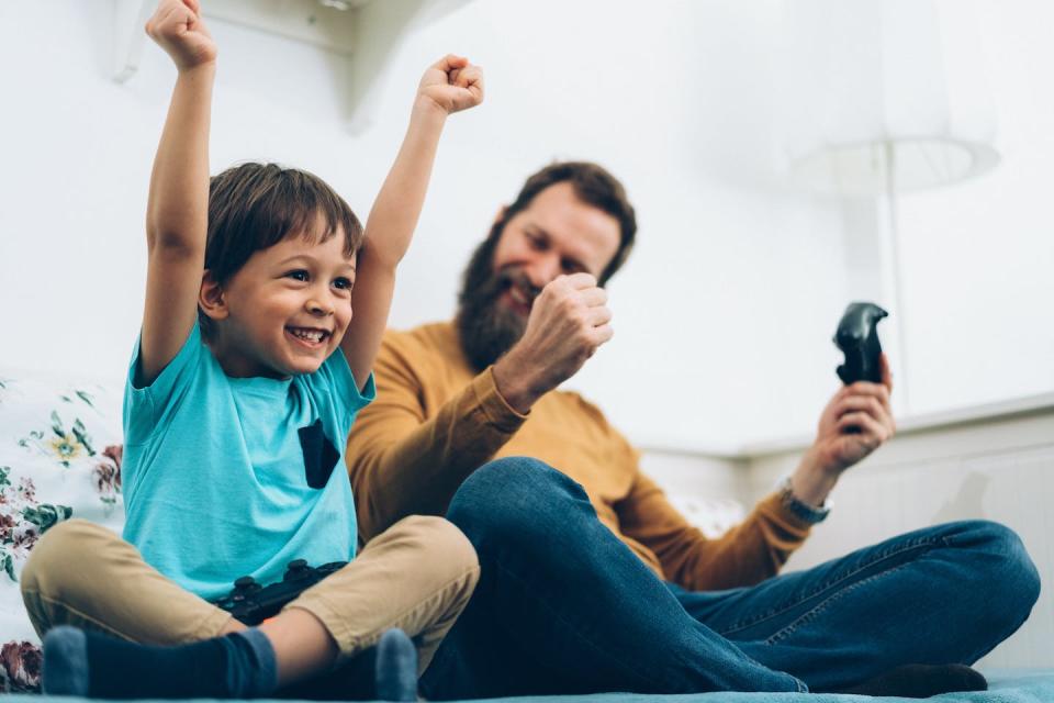 Sweet victory often involves teamwork. <a href="https://www.gettyimages.com/detail/photo/father-and-son-playing-video-games-at-home-royalty-free-image/1203984161" rel="nofollow noopener" target="_blank" data-ylk="slk:martin-dm/E+ via Getty Images;elm:context_link;itc:0;sec:content-canvas" class="link ">martin-dm/E+ via Getty Images</a>