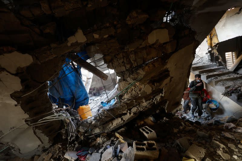 People search for casualties at the site at the site of Israeli strikes on houses, in Rafah