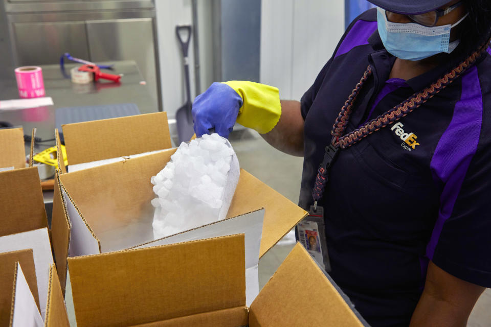 Un empleado de FedEx manipula hielo seco para las cajas que se usarían en el envío de las vacunas. (FedEx vía The New York Times)