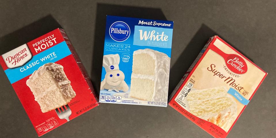 Duncan Hines, Pillsbury, and Betty Crocker boxed cake mixes in vanilla flavors lying on a table