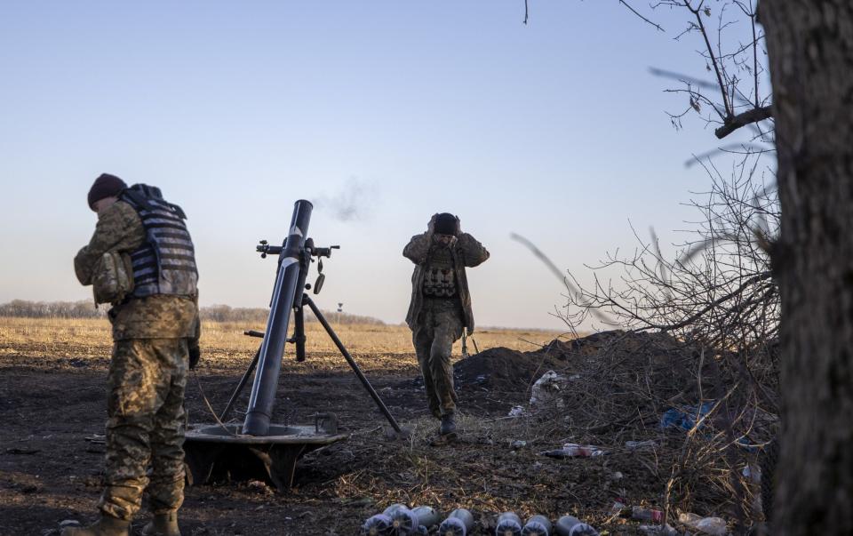 DONETSK OBLAST, UKRAINE - JANUARY 26: Ukrainian servicemen take cover as they fire a mortar load on the Donbass frontline as military mobility continues within the Russian-Ukrainian war, on January 26, 2023. (Photo by Mustafa Ciftci/Anadolu Agency via Getty Images) - Mustafa Ciftci/Anadolu Agency