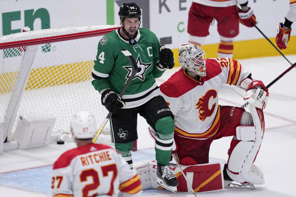 Dallas Stars left wing Jamie Benn celebrates after scoring against Calgary Flames' Jacob Markstrom as Nick Ritchie (27) looks on in the third period of an NHL hockey game, Monday, March 6, 2023, in Dallas. (AP Photo/Tony Gutierrez)