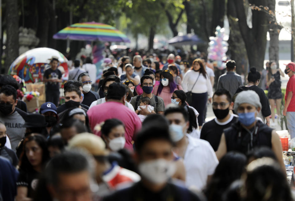 Families walk along Mexico City's Reforma Avenue during Day of the Dead celebrations, Sunday, Oct. 18, 2020. (AP Photo/Eduardo Verdugo)