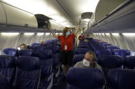 FILE - In this May 24, 2020, file photo, a Southwest Airlines flight attendant prepares a plane bound for Orlando, Fla. for takeoff at Kansas City International airport in Kansas City, Mo. About 40,000 workers in the airline industry are facing layoffs on Thursday, Oct. 1, unless Congress comes up with another aid package. (AP Photo/Charlie Riedel, File)