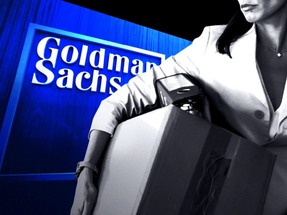 Woman holding boxes leaving in front of the Goldman Sachs logo