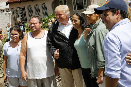 U.S. President Donald Trump and first lady Melania Trump pose with residents while surveying hurricane damage in San Juan, Puerto Rico, U.S., October 3, 2017. REUTERS/Jonathan Ernst