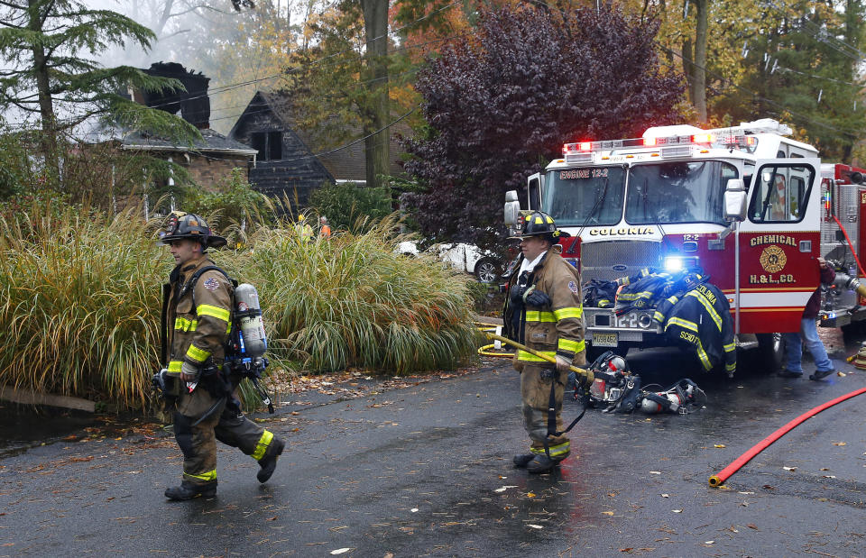 Woodbridge firefighters work the scene of fire after a plane crashed into a home located at 84 Berkeley Ave. Tuesday, Oct. 29, 2019, in Woodbridge,N.J. (AP Photo/Noah K. Murray)