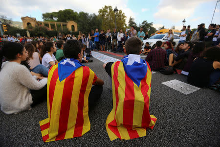 Students wear Esteladas (Catalan separatist flags) as they block a street during a gathering to protest against the imprisonment of leaders of two of the largest Catalan separatist organizations, Catalan National Assembly's Jordi Sanchez and Omnium's Jordi Cuixart, who were jailed by Spain's High Court, in Barcelona, Spain, October 17, 2017. REUTERS/Ivan Alvarado