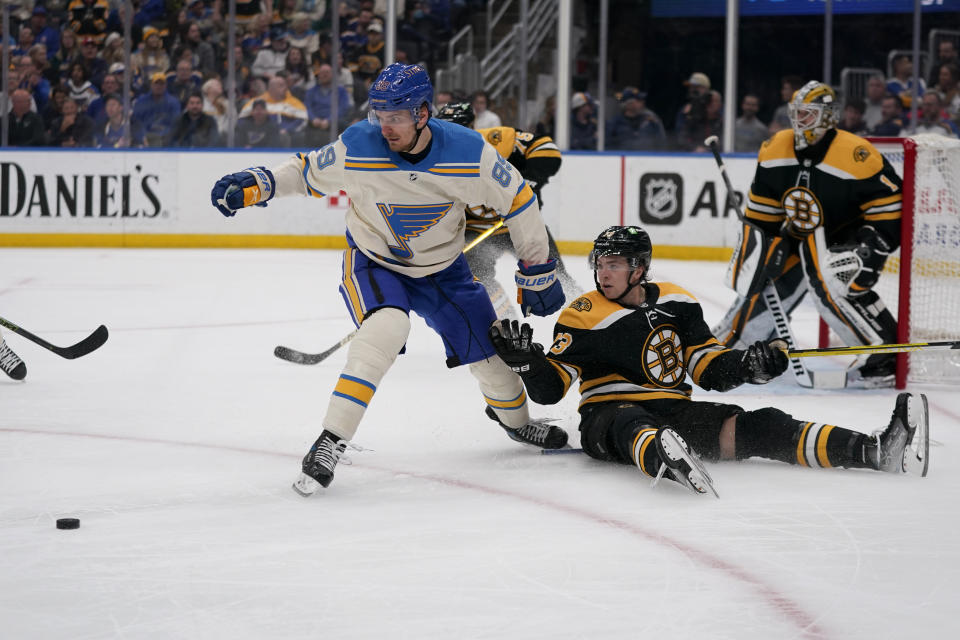 St. Louis Blues' Pavel Buchnevich (89) looks at the puck after loosing his stick as Boston Bruins' Charlie McAvoy (73) sits on the ice during the second period of an NHL hockey game Tuesday, April 19, 2022, in St. Louis. (AP Photo/Jeff Roberson)