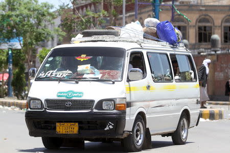 Internally displaced people with luggage ride in a van as they flee from an airstrike on an army weapons depot in Yemen's capital Sanaa May 12, 2015. REUTERS/Mohamed al-Sayaghi