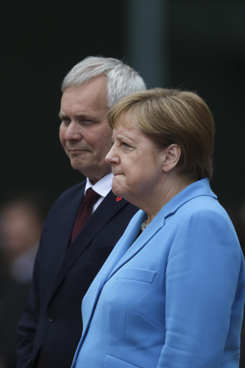 German Chancellor Angela Merkel, right, and Prime Minister of Finland Antti Rinne listen to the national anthems at the chancellery in Berlin, Wednesday, July 10, 2019. Merkel's body shook visibly as she stood alongside the Finnish prime minister and listen to the national anthems during the welcoming ceremony at the chancellery. (AP Photo/Markus Schreiber)