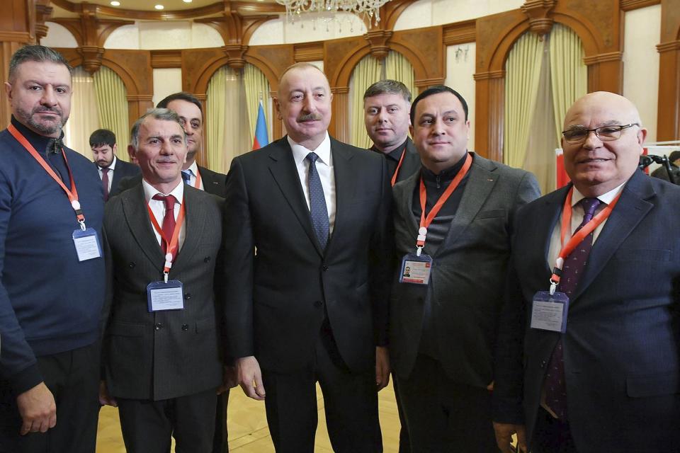 In this photo provided by the Azerbaijan's Presidential Press Office, Azerbaijan's President Ilham Aliyev, center, poses for a photo with members of an election commission after voting during presidential election at a polling station in Khankendi, Karabakh region, Azerbaijan, Wednesday, Feb. 7, 2024. Azerbaijanis are voting Wednesday in an election almost certain to see incumbent President Ilham Aliyev chosen to serve another seven-year term. (Azerbaijani Presidential Press Office via AP)