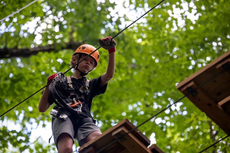 Max Pramik, 12, carefully crosses a platform at the TimberTrek Adventure Park, part of the Adventures on the Gorge resort.