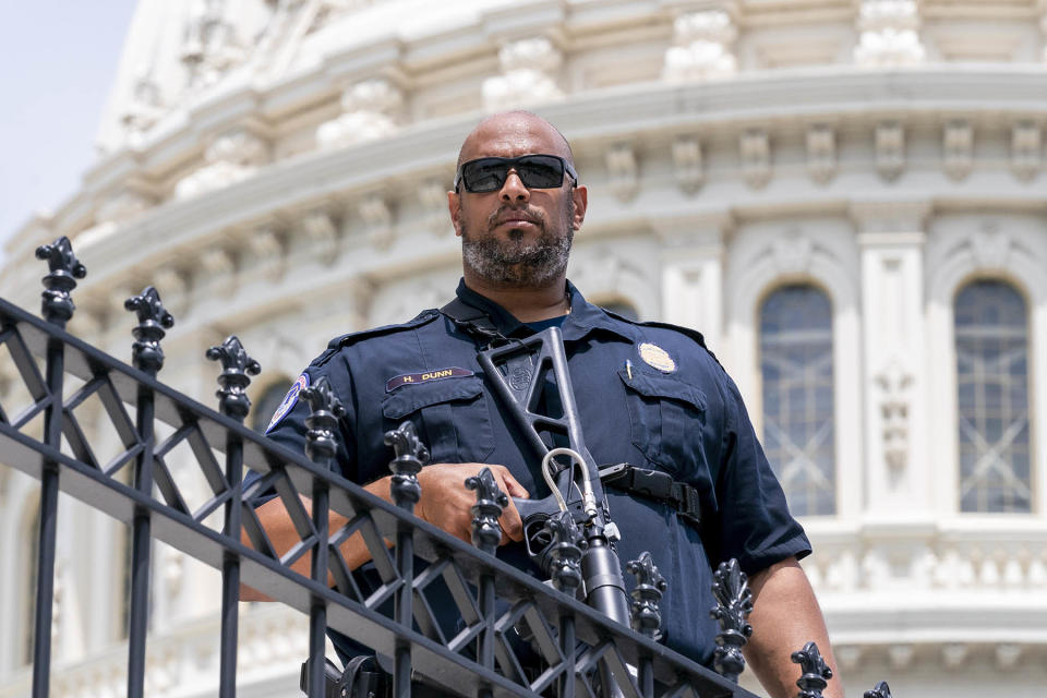 U.S. Capitol Police Sgt. Harry Dunn, who defended the Capitol when pro-Trump insurrectionists attacked Jan. 6, 2021, keeps watch over the East Plaza while Speaker of the House Nancy Pelosi, D-Calif., and other lawmakers hold an event on the House steps, at the Capitol in Washington, Friday, June 24, 2022. (AP Photo/J. Scott Applewhite)