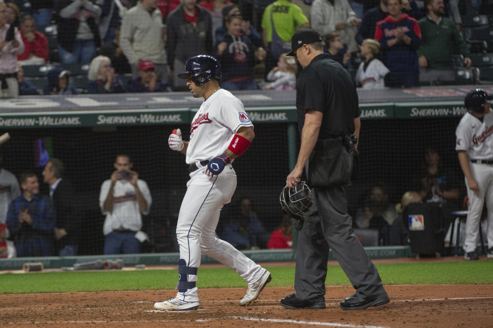 Cleveland Guardians' Ramon Laureano touches home plate on his solo home run, as umpire Roberto Ortiz watches during the fifth inning of the team's baseball game against the Texas Rangers in Cleveland on Friday, Sept. 15, 2023. (AP Photo/Phil Long)