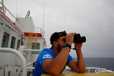 A crew member on the Migrant Offshore Aid Station (MOAS) ship Topaz Responder keeps a look out for migrants in distress in international waters off the coast of Libya, June 21, 2016. REUTERS/Darrin Zammit Lupi