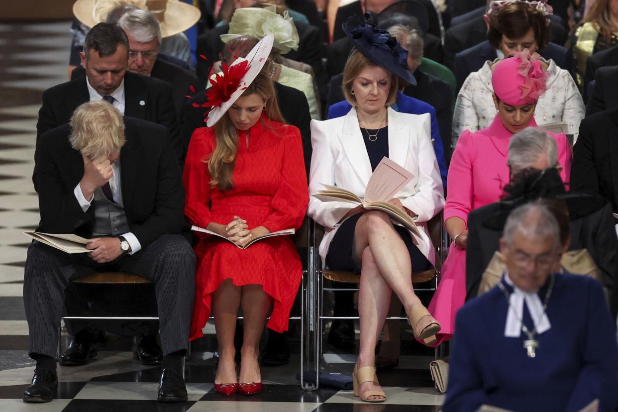 British Prime Minister Boris Johnson, far left, reacts as he sits next to his wife Carrie Johnson, British Foreign Secretary Liz Truss and Home Secretary Priti Patel, right, at the National Service of Thanksgiving held at St Paul's Cathedral as part of celebrations marking the Platinum Jubilee of Britain's Queen Elizabeth II, in London, Friday, June 3, 2022. 